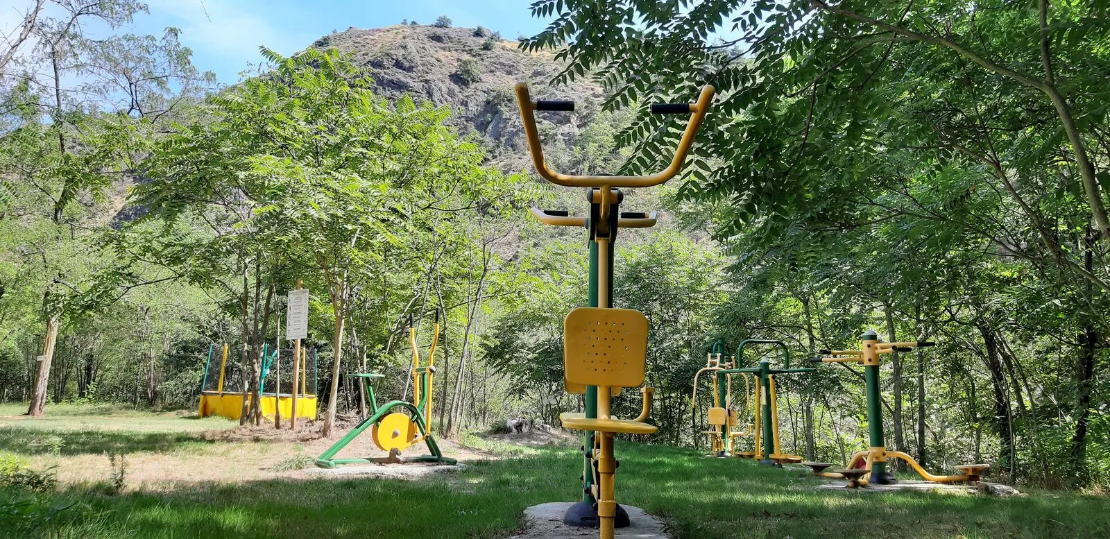 Die gelben Fitnessgeräte auf der Wiese, am Flussufer