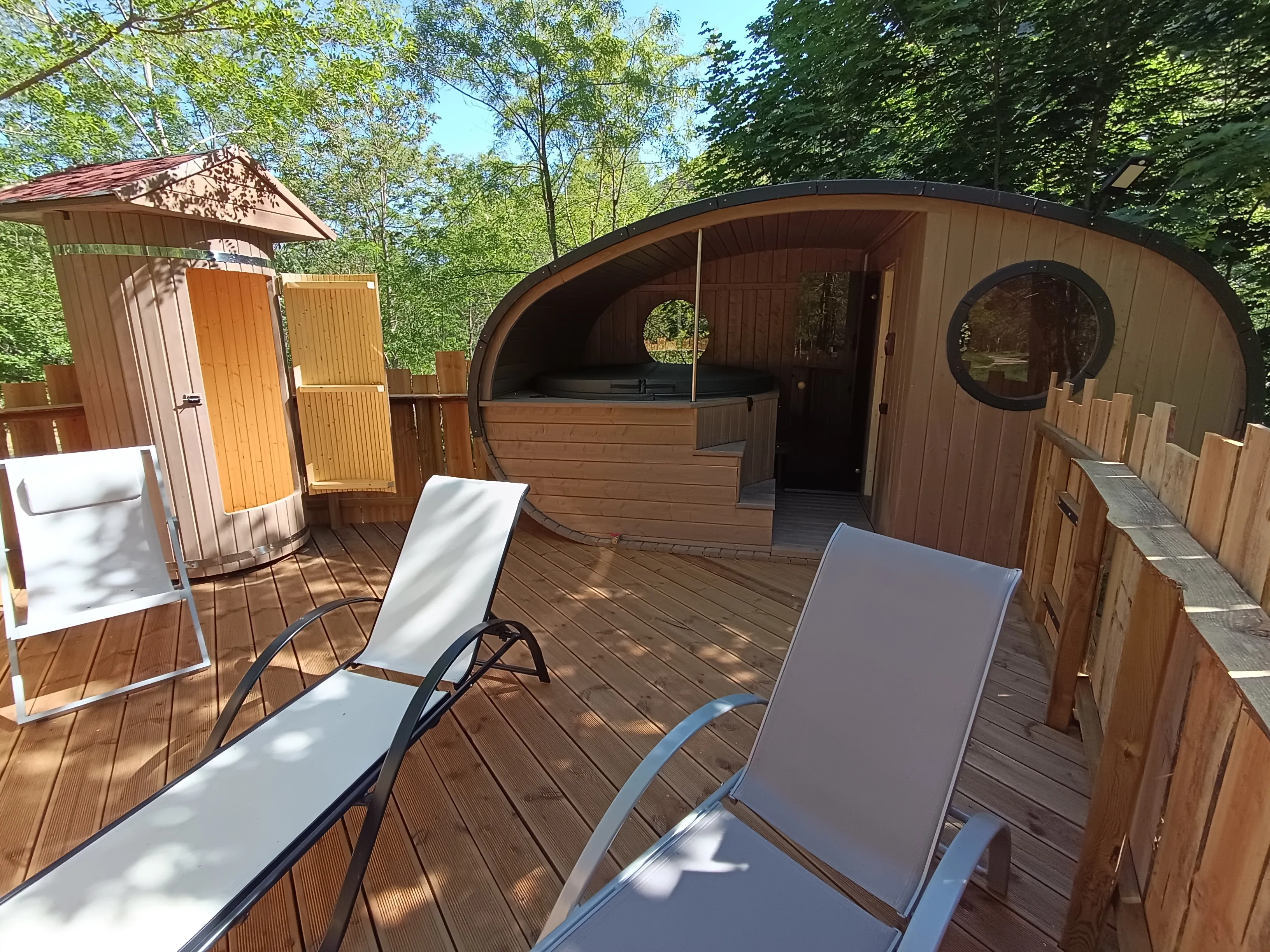 Der Wellnessbereich: Sauna und Spa aus Holz, unter den Bäumen