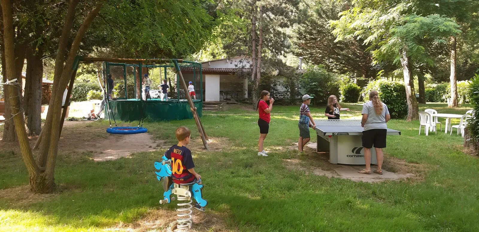 Eine Runde Tischtennis im Schatten der Bäume, neben den Spielgeräten
