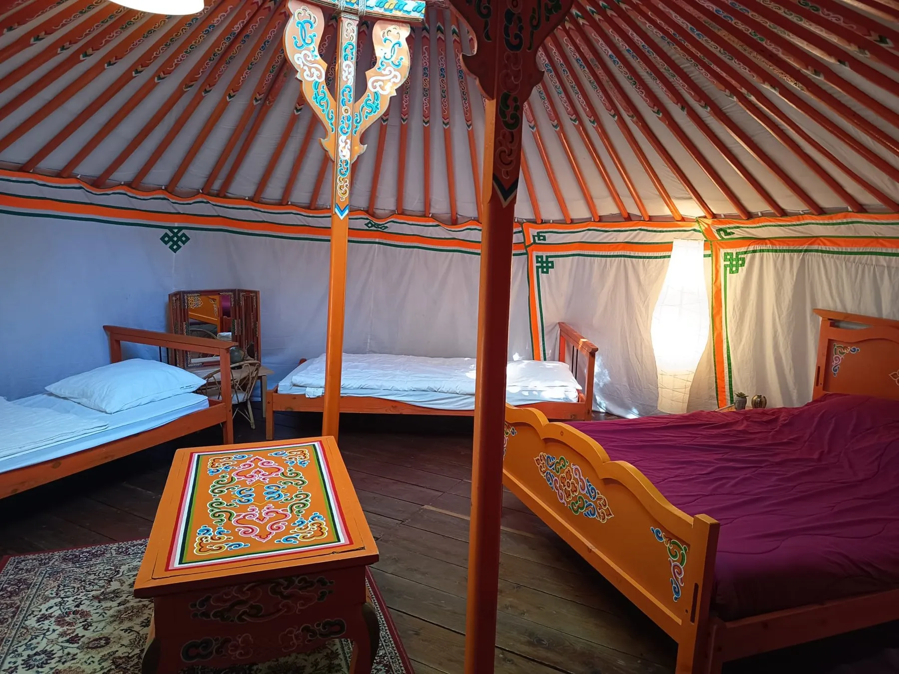 Das Innere der mongolischen Jurte Nr. 14 mit Doppelbett und Einzelbetten